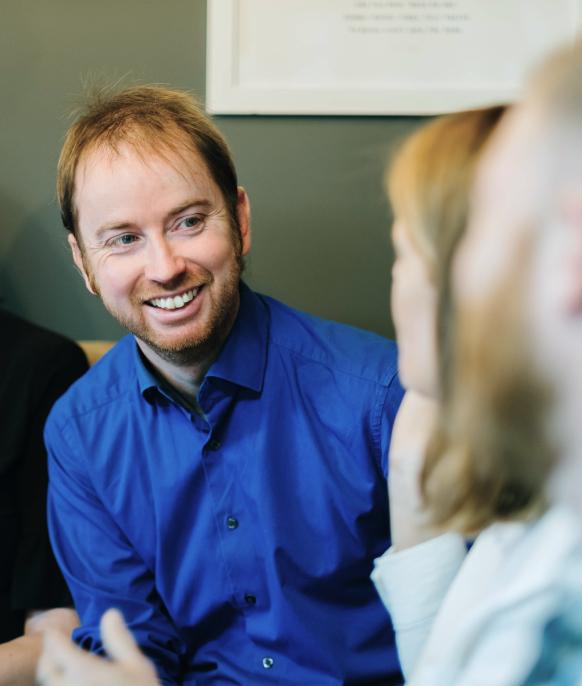 Tim, director of Elite Travel Management, smiling and talking to a client